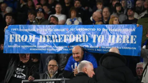 Getty Images Fans of Brighton & Hove Albion show their support with a banner reading 'From Hereford to here' during the UEFA Europa League round of 16 second leg match between Brighton & Hove Albion and AS Roma.