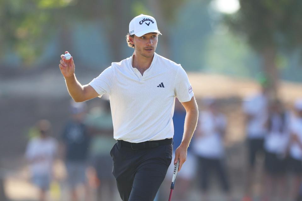 Rasmus Hojgaard acknowledges the crowd on the 15th green on day four of the DP World Tour Championship 2024 at Jumeirah Golf Estates.