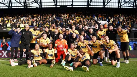 PA Media File photo dated 27-01-2024 of Maidstone United players and staff celebrate the win. National League South outfit Maidstone stunned Championship high-flyers Ipswich with a 2-1 victory to secure their place in the fifth round of the FA Cup.