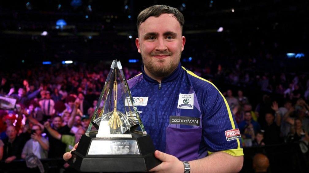 Luke Littler with the Premier League trophy after winning the title in May