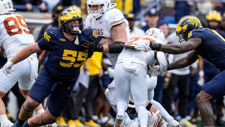 Michigan defensive lineman Mason Graham (55) and defensive end Derrick Moore (8) tackle Texas running back Jaydon Blue (23) during the second half at Michigan Stadium in Ann Arbor on Saturday, September 7, 2024.