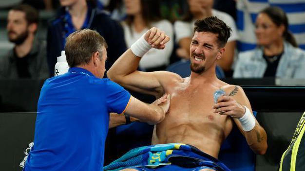 Thanasi Kokkinakis receives treatment on his shoulder during his Australian Open match against Jack Draper