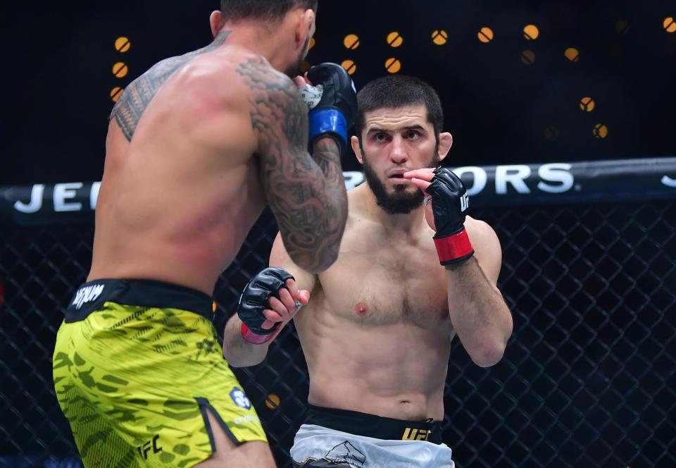 Jan 18, 2025; Inglewood, California, USA; Islam Makhachev (red gloves) fights Renato Moicano (blue gloves) in a lightweight title fight during UFC 311 at Intuit Dome. Mandatory Credit: Gary A. Vasquez-Imagn Images