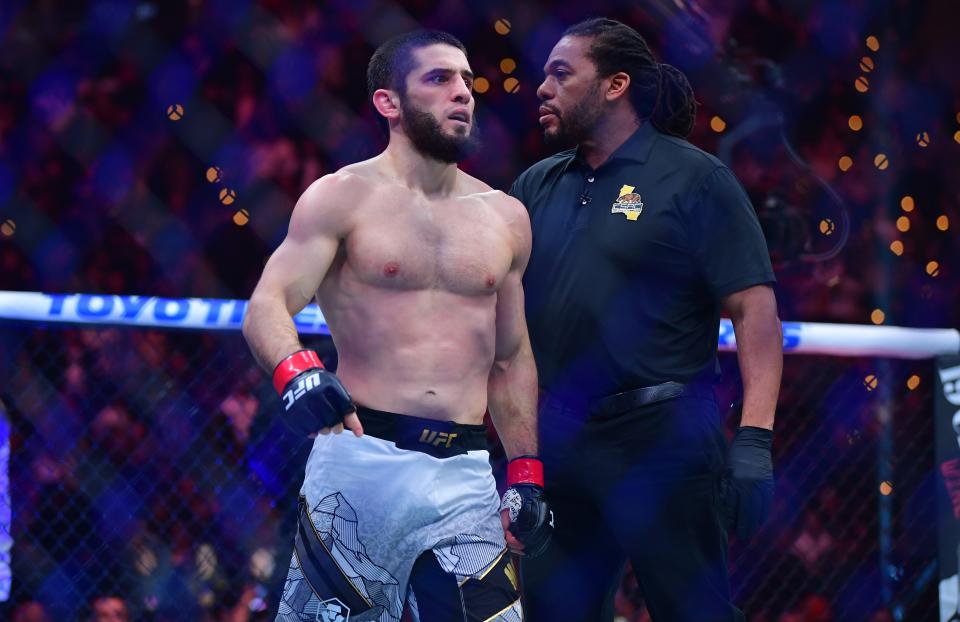 Jan 18, 2025; Inglewood, California, USA; Islam Makhachev (red gloves) reacts after defeating Renato Moicano (blue gloves) in a lightweight title fight during UFC 311 at Intuit Dome. Mandatory Credit: Gary A. Vasquez-Imagn Images