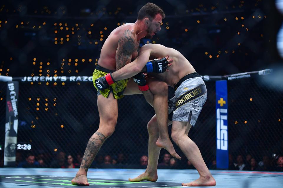 Jan 18, 2025; Inglewood, California, USA; Islam Makhachev (red gloves) fights Renato Moicano (blue gloves) in a lightweight title fight during UFC 311 at Intuit Dome. Mandatory Credit: Gary A. Vasquez-Imagn Images