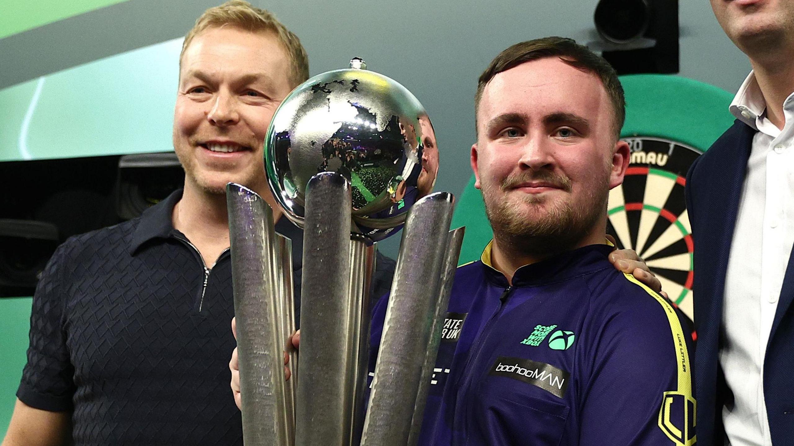 Luke Littler gets the Sid Waddell Trophy from Sir Chris Hoy after winning the PDC World Darts Championship