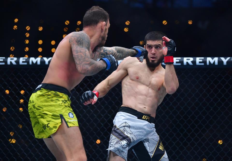 Jan 18, 2025; Inglewood, California, USA; Islam Makhachev (red gloves) fights Renato Moicano (blue gloves) in a lightweight title fight during UFC 311 at Intuit Dome. Mandatory Credit: Gary A. Vasquez-Imagn Images