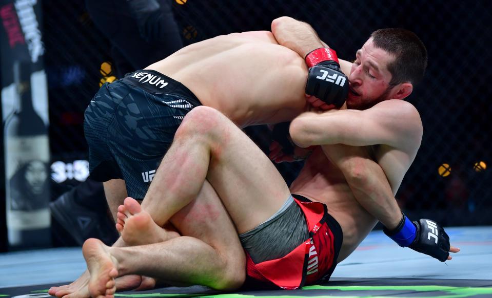 Jan 18, 2025; Inglewood, California, USA; Tagir Ulanbekov (red gloves) fights Clayton Carpenter (blue gloves) during UFC 311 at Intuit Dome. Mandatory Credit: Gary A. Vasquez-Imagn Images