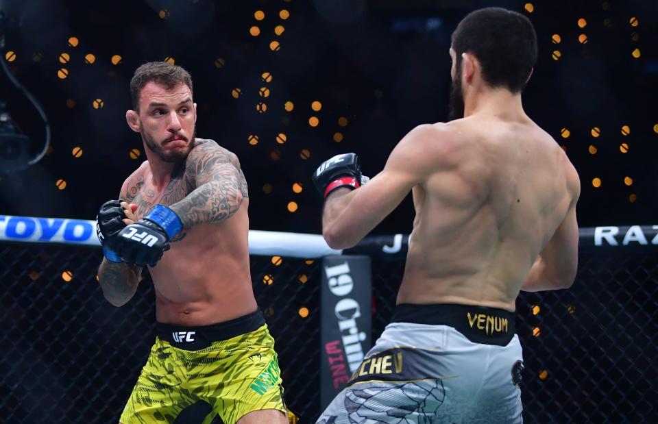 Jan 18, 2025; Inglewood, California, USA; Islam Makhachev (red gloves) fights Renato Moicano (blue gloves) in a lightweight title fight during UFC 311 at Intuit Dome. Mandatory Credit: Gary A. Vasquez-Imagn Images