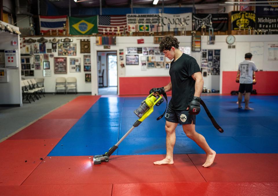 Austin Bashi, of West Bloomfield, uses a vacuum to pick up foam that was shed from striking a ground punching bag at the end of MMA training at Warrior Way Martial Arts Allnc in Commerce Township on Friday, December 20, 2024. Bashi is about to make his UFC debut in early January in Las Vegas and is regarded as the top UFC prospect in the country.