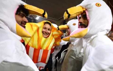 Reuters Three people dressed as seagulls and a person dressed as chips