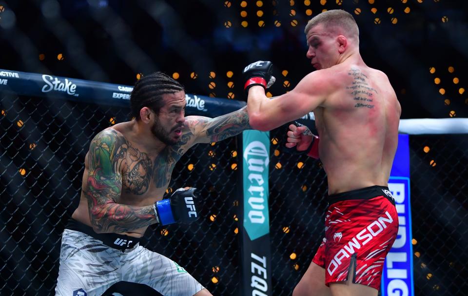 Jan 18, 2025; Inglewood, California, USA; Grant Dawson (red gloves) fights Diego Ferreira (blue gloves) during UFC 311 at Intuit Dome. Mandatory Credit: Gary A. Vasquez-Imagn Images