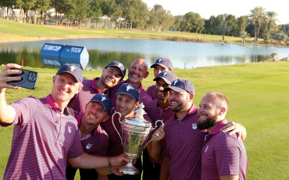 Aaron Rai, Tom McKibbin, Paul Waring, Matthew Jordan, Justin Rose, Tommy Fleetwood, Matt Wallace, Jordan Smith and Laurie Canter of Team Great Britain & Ireland pose for a selfie with the trophy following victory at the Team Cup at Abu Dhabi Golf Resort on January 12