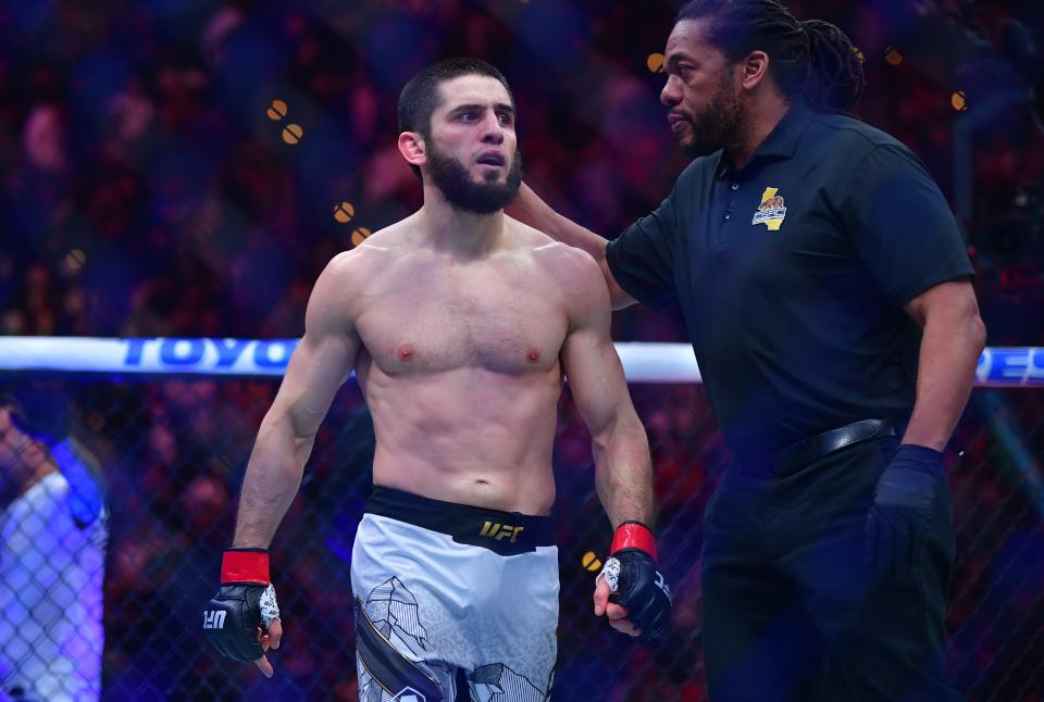 Jan 18, 2025; Inglewood, California, USA; Islam Makhachev (red gloves) reacts after defeating Renato Moicano (blue gloves) in a lightweight title fight during UFC 311 at Intuit Dome. Mandatory Credit: Gary A. Vasquez-Imagn Images