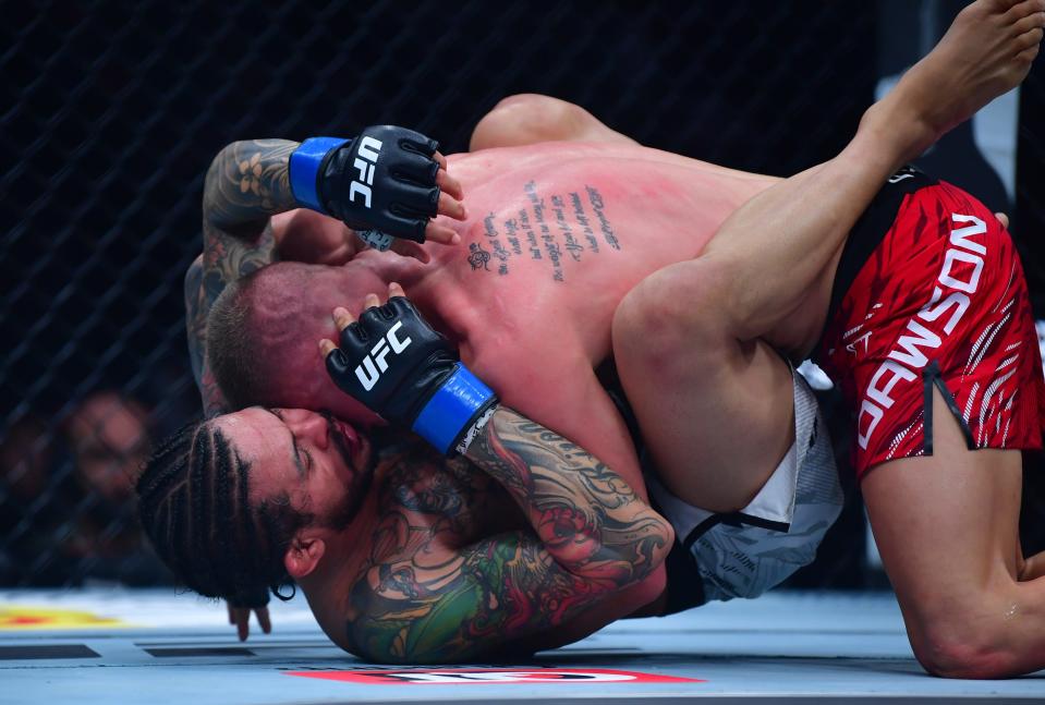 Jan 18, 2025; Inglewood, California, USA; Grant Dawson (red gloves) fights Diego Ferreira (blue gloves) during UFC 311 at Intuit Dome. Mandatory Credit: Gary A. Vasquez-Imagn Images