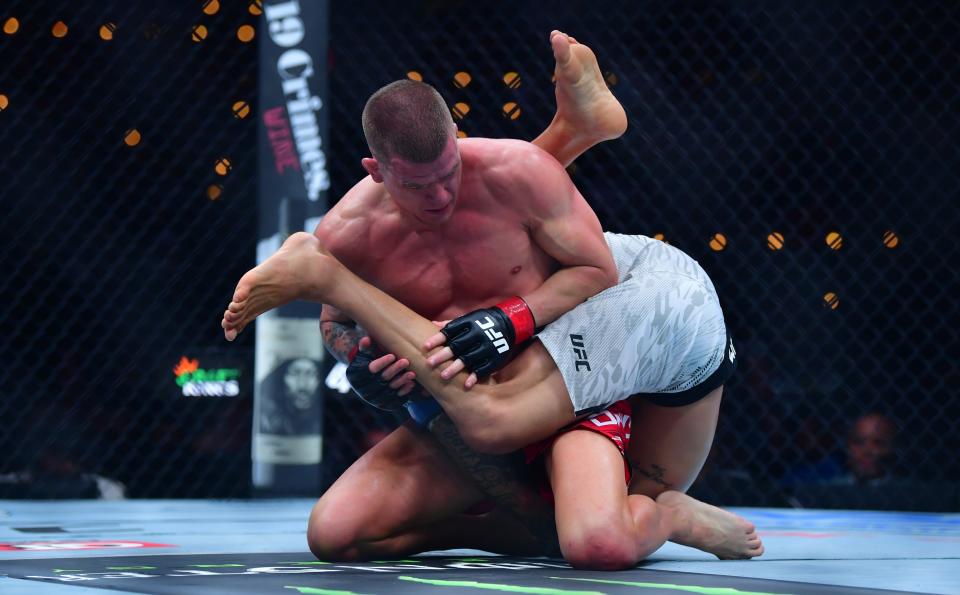 Jan 18, 2025; Inglewood, California, USA; Grant Dawson (red gloves) fights Diego Ferreira (blue gloves) during UFC 311 at Intuit Dome. Mandatory Credit: Gary A. Vasquez-Imagn Images