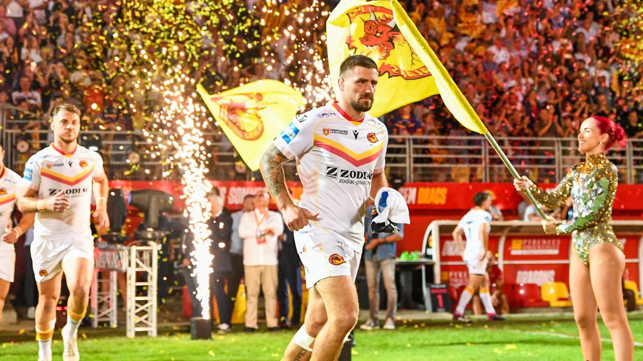 Micky McIlorum emerges from the tunnel at Catalans Dragons' Stade Gilbert Brutus to pyrotechnics, ticker-tape, and flag bearers as the teams run out for the Super League play-off semi final against St Helens.