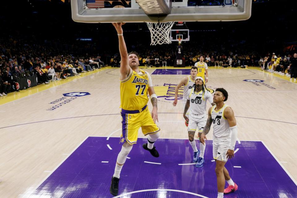 Lakers guard Luka Doncic scores on a layup in front of Utah Jazz guard Keyonte George in the first half Monday.