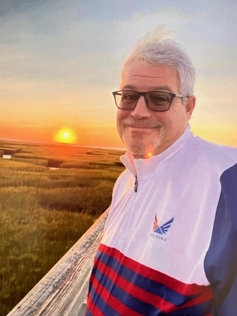 Jeff Babineau watches a sun rise in his native Cape Cod, wearing a Folds of Honor jacket.