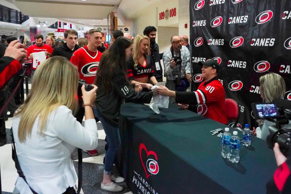 Feb 25, 2020; Raleigh, North Carolina, USA; Carolina Hurricanes emergency goaltender David Ayres signs autographs for fans before a game against the Dallas Stars at PNC Arena. (James Guillory-Imagn Images)