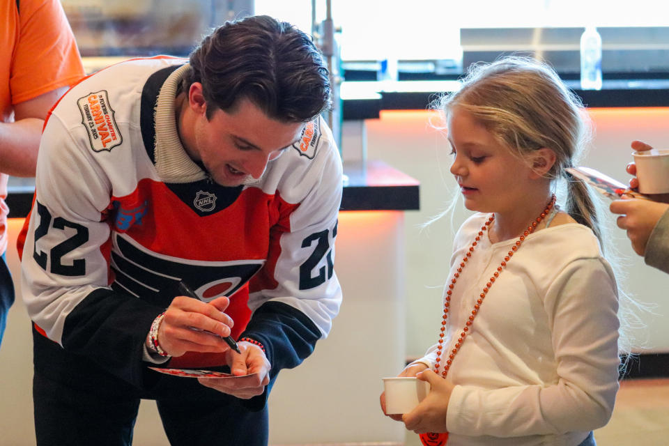 Philadelphia Flyers forward Jakob Pelletier (22) signs an item for a young fan. (Megan DeRuchie-The Hockey News)