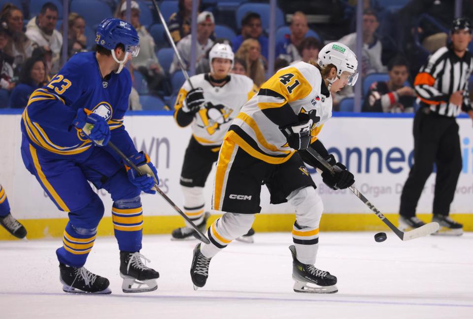 Sep 21, 2024; Buffalo, New York, USA; Buffalo Sabres defenseman Mattias Samuelsson (23) watches as Pittsburgh Penguins center Ville Koivunen (41) tries to control the puck during the first period at KeyBank Center. (Timothy T. Ludwig-Imagn Images)