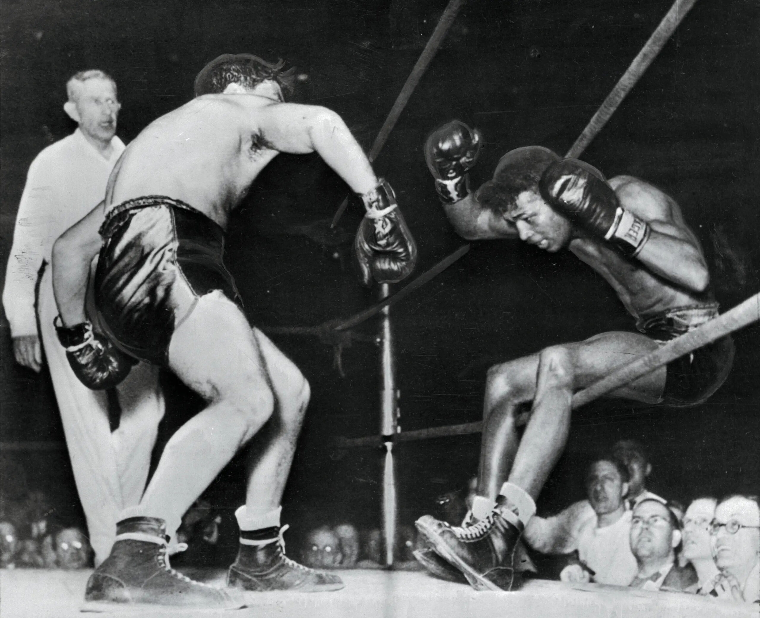 (Original Caption) Victorious in 129 successive fights, including 40 as a pro, Ray Robinson falls through the ropes of a Detroit ring, under the impact of Jake LaMotta's fists. Robinson got back in the ring, but lost the decision in ten rounds.