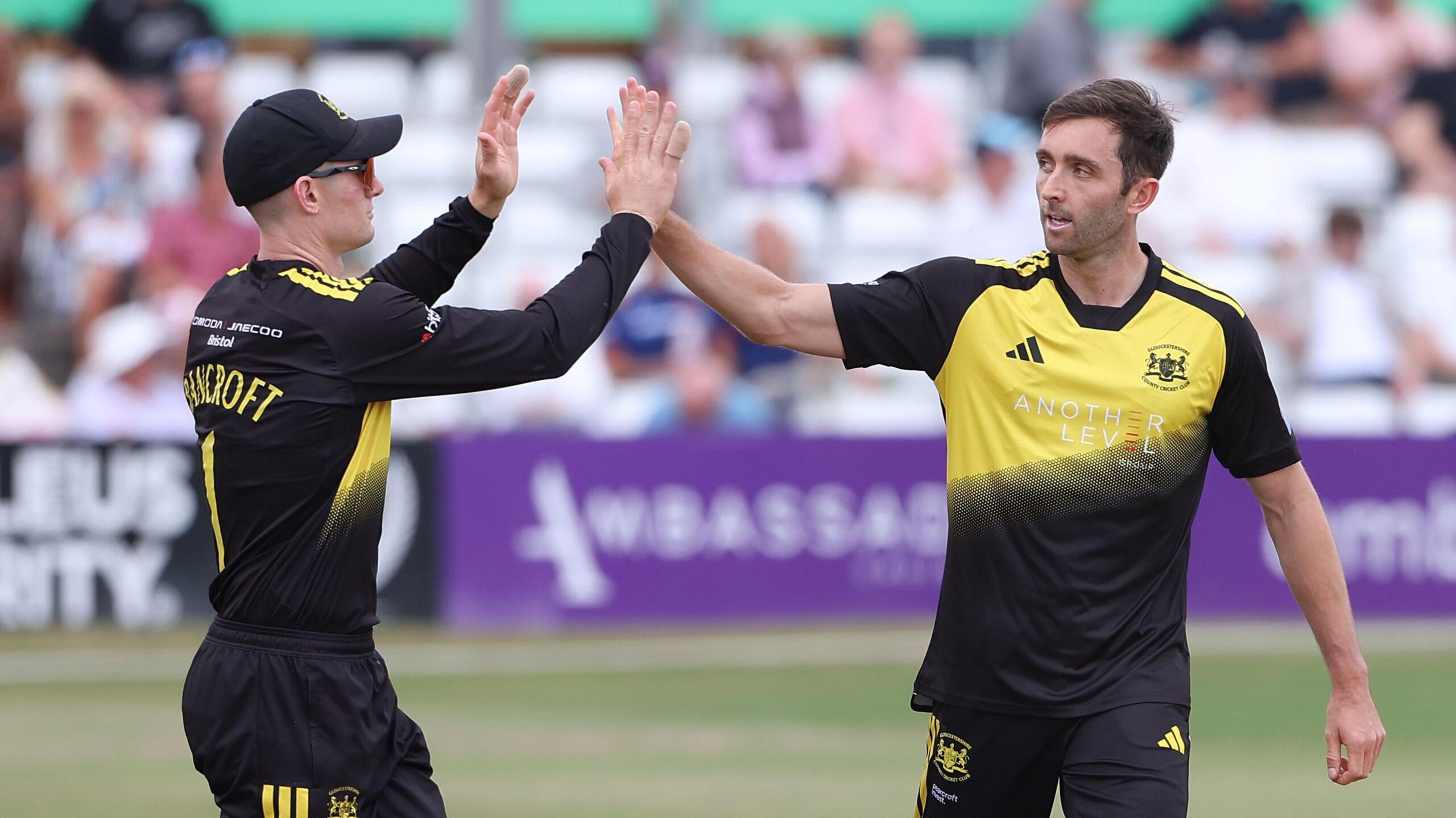Cameron Bancroft (left) holds two hands in the air to clap hands with team-mate Matt Taylor