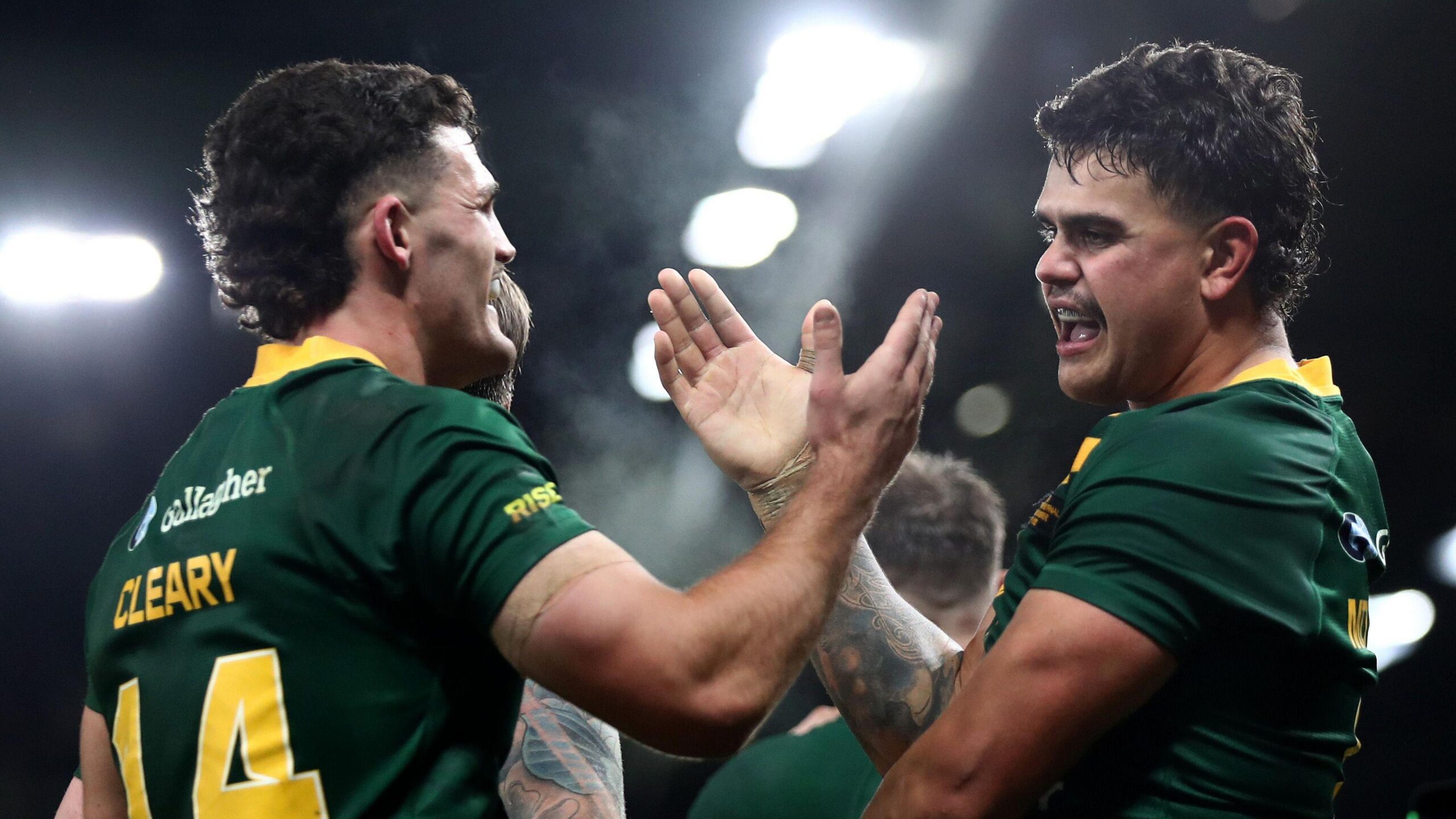 Nathan Cleary and Latrell Mitchell embrace with a handshake and hug after Australia score a try against Samoa in the Rugby League World Cup final in 2022