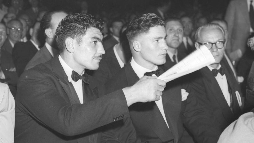 Jack Gardner and Don Cockell sat at ground level watching a boxing fight