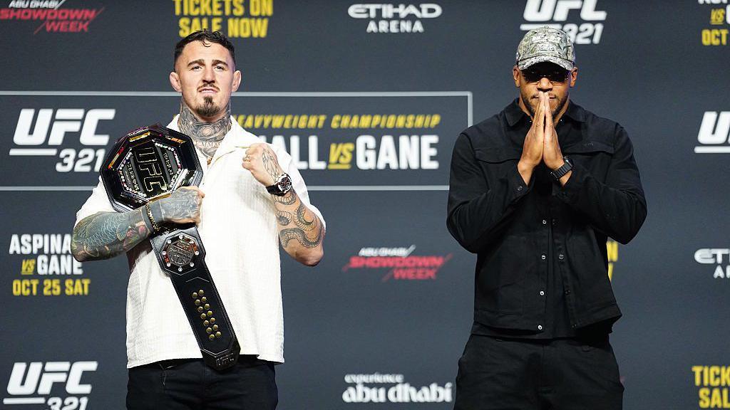 Tom Aspinall holds his UFC belt standing beside Ciryl Gane