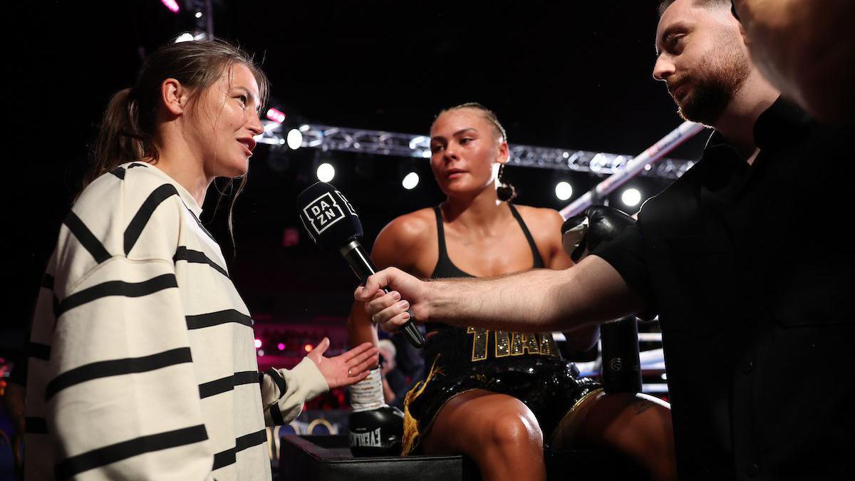 Katie Taylor speaks at ringside to DAZN with Tiah-Mai Ayton beside her