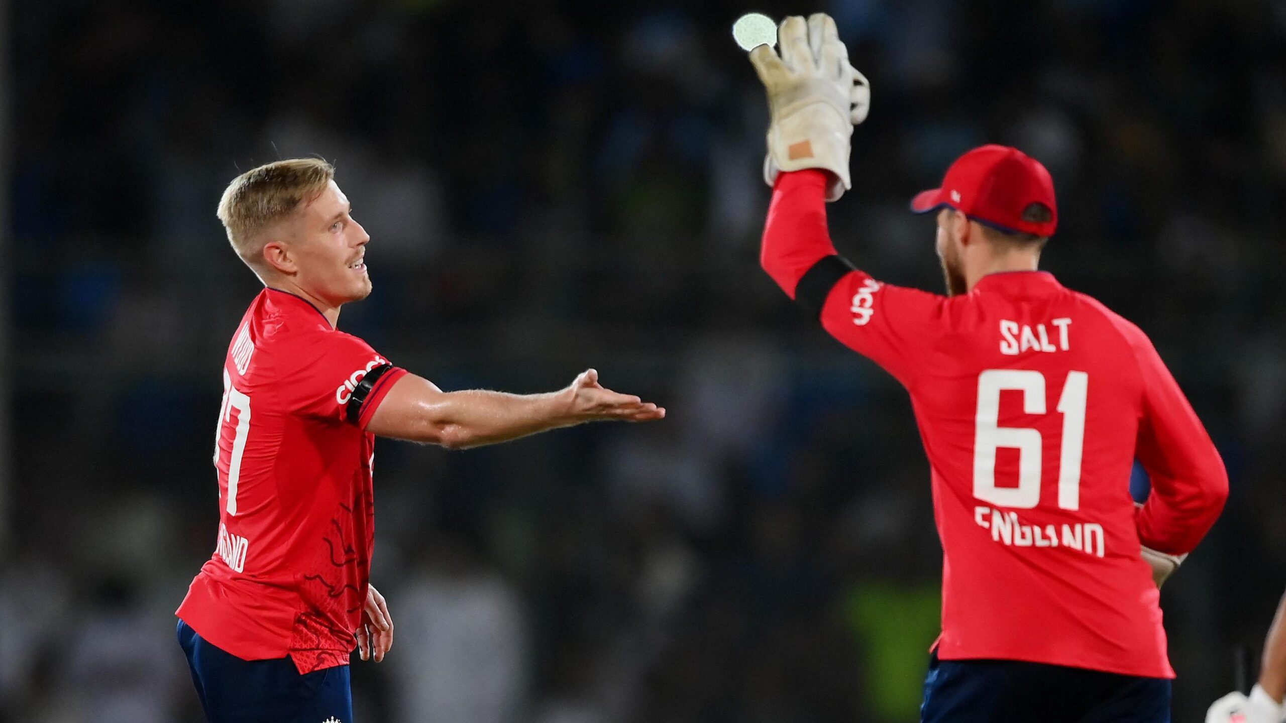 Luke Wood (left) gets congratulated by Phil Salt (wearing no.61) in his wicketkeeper gloves in a T20 international for England