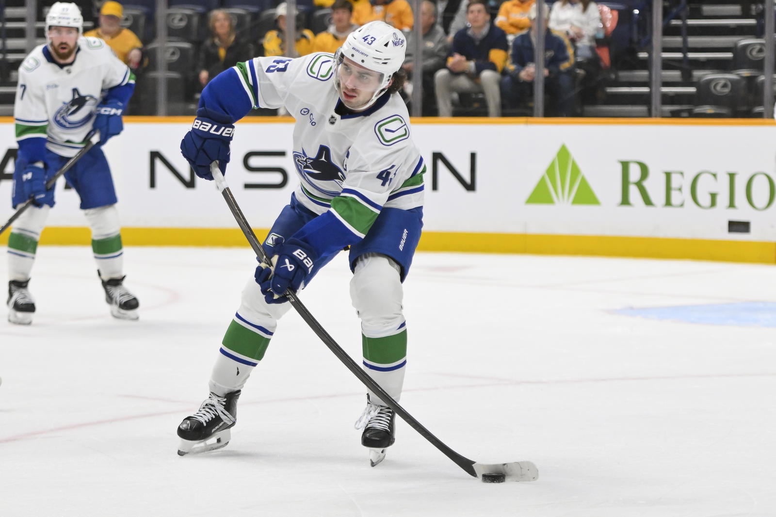 Oct 23, 2025; Nashville, Tennessee, USA; Vancouver Canucks defenseman Quinn Hughes (43) passes the puck against the Nashville Predators during the third period at Bridgestone Arena. Mandatory Credit: Steve Roberts-Imagn Images