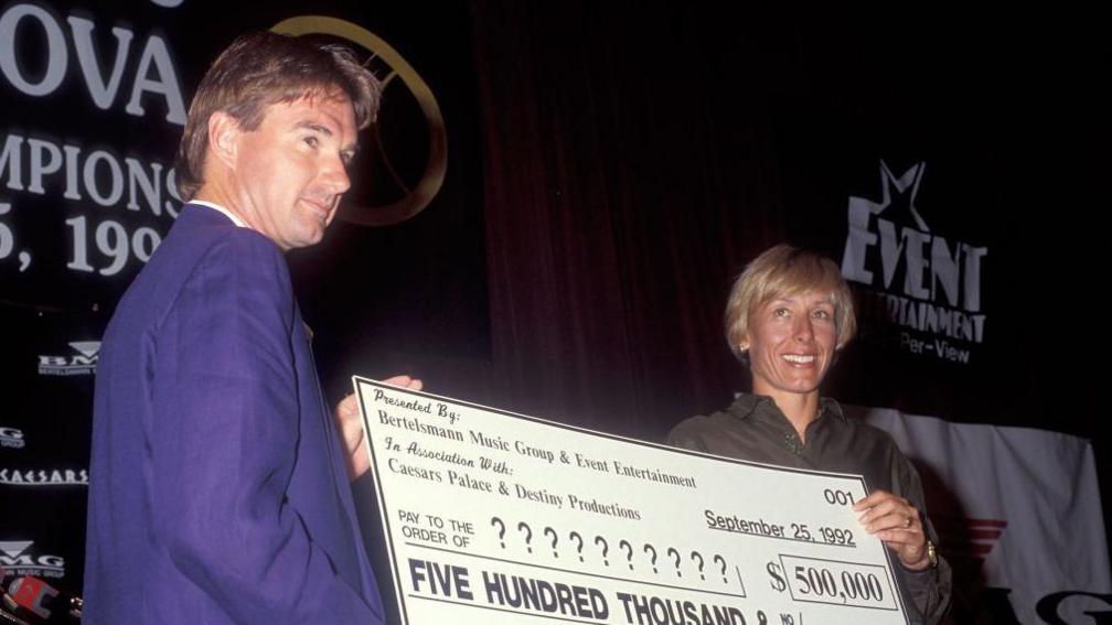 Jimmy Connors and Martina Navratilova posing with a $500,000 cheque